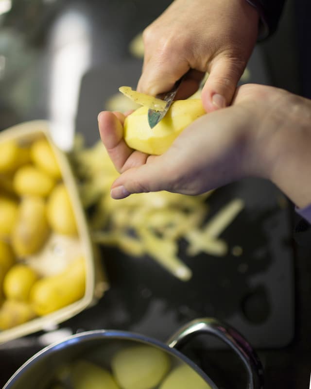 Eine Frau schält Kartoffeln. Eine Frau schält Kartoffeln.