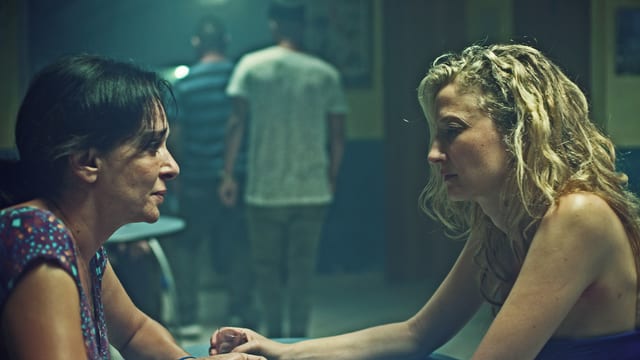 Zwei Frauen sitzen sich in einer Bar gegenüber. Die eine schaut der anderen in die Augen, diese schaut auf den Tisch. Zwei Frauen sitzen sich in einer Bar gegenüber. Die eine schaut der anderen in die Augen, diese schaut auf den Tisch.