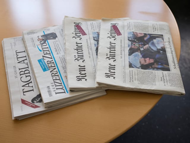 Zeitungen auf Tisch.