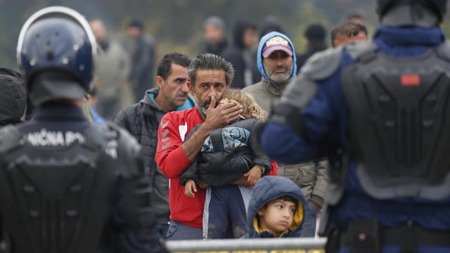 Bosnische Polizisten mit Migranten an der kroatischen Grenze. Bosnische Polizisten mit Migranten an der kroatischen Grenze.