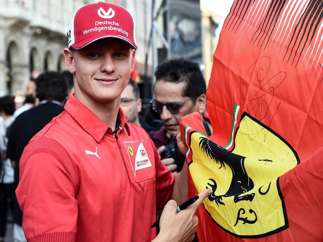 Mick Schumacher unterschreibt eine Flagge Mick Schumacher unterschreibt eine Flagge