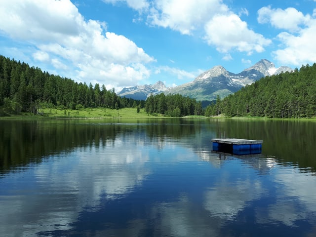 Die Wolken spiegeln sich im Stazersee.