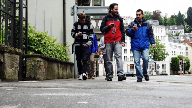 Die Gruppe zieht durch die Strassen von St. Gallen. Ihr Telefon haben sie immer im Blick. Die Gruppe zieht durch die Strassen von St. Gallen. Ihr Telefon haben sie immer im Blick.
