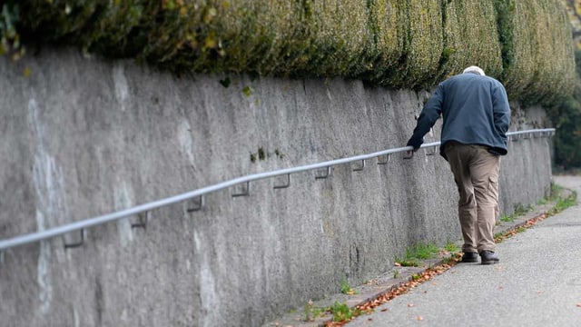 Senior hält sich an Stange fest Senior hält sich an Stange fest