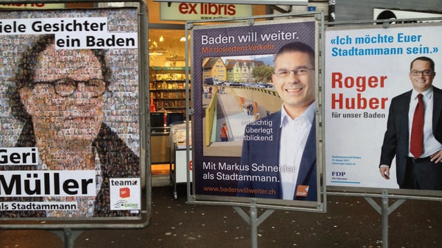 Wahlplakate von Geri Müller, Markus Schneider und Roger Huber vor einem Musikgeschäft in Baden.