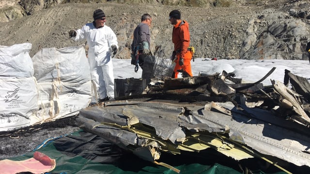 Männer auf Gletscher bei Teilen von Flugzeugwrack. Männer auf Gletscher bei Teilen von Flugzeugwrack.