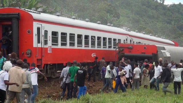 Menschen scharen sich in Kamerun nach Zugunglück um die entgleisten Waggons. Menschen scharen sich in Kamerun nach Zugunglück um die entgleisten Waggons.