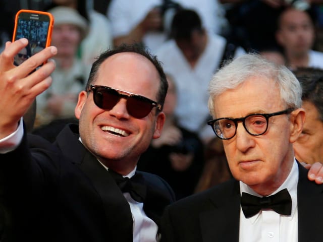 Ein Mann schiesst auf dem roten Teppich von Cannes ein Selfie mit Woody Allen, gegen dessen Willen. Ein Mann schiesst auf dem roten Teppich von Cannes ein Selfie mit Woody Allen, gegen dessen Willen.