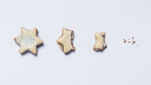 Links ein ganzer Zimtstern, rechts daneben ein halber, ein Viertel und ein paar Krümel. Links ein ganzer Zimtstern, rechts daneben ein halber, ein Viertel und ein paar Krümel.