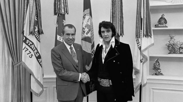 eine schwarz-weiss Fotografie vom Händeschütteln zwischen Präsident Nixon und Elvis Presley eine schwarz-weiss Fotografie vom Händeschütteln zwischen Präsident Nixon und Elvis Presley