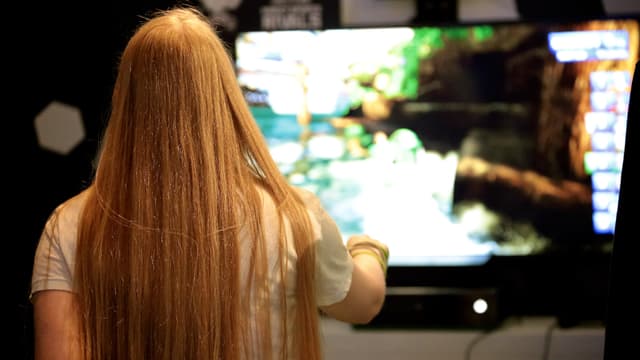 Eine Frau mit langen rotblonden Haaren spielt ein Jet-Ski-Spiel.