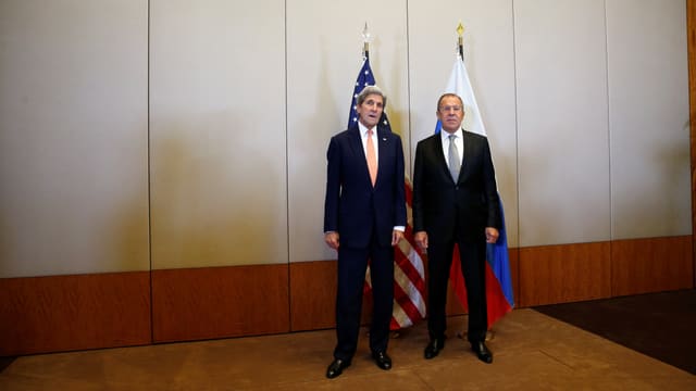 Kerry und Lawrow vor einer US- und einer Russland-Flagge.