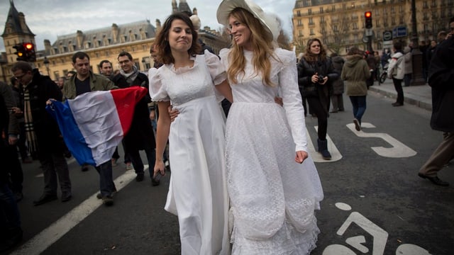 Ein gleichgeschlechtliches Liebespaar in Brautkleid demonstriert in Paris für die Homo Ehe.