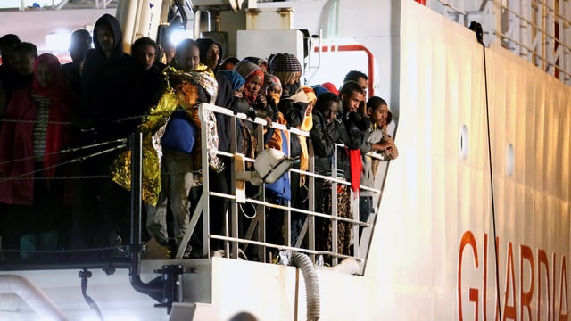 Flüchtlinge erreichen auf einem Schiff der Küstenwache den Hafen von Palermo. 
