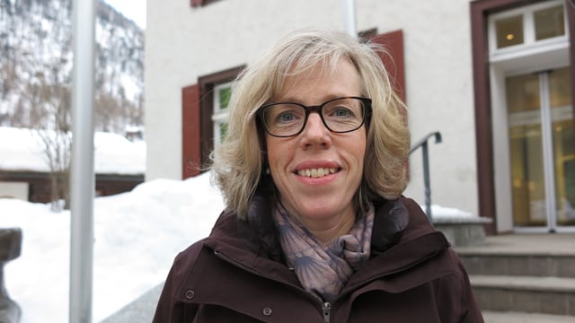 Eine Frau blickt in die Kamera. Im Hintergrund ist eine Treppe, daneben viel Schnee. Eine Frau blickt in die Kamera. Im Hintergrund ist eine Treppe, daneben viel Schnee.