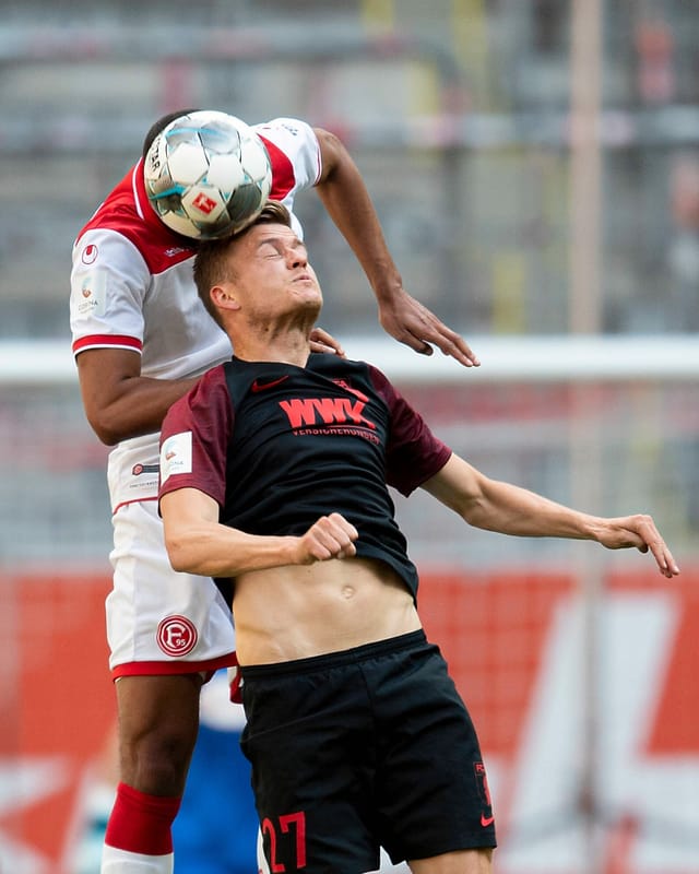 Augsburgs Alfred Finnbogason (unten) im Duell mit Duell mit Mathias Jörgensen von Fortuna Düsseldorf.