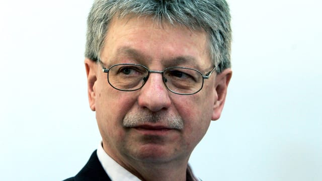 Ein Mann mit Brille und Schnauz; er schaut eher skeptisch. Ein Mann mit Brille und Schnauz; er schaut eher skeptisch.