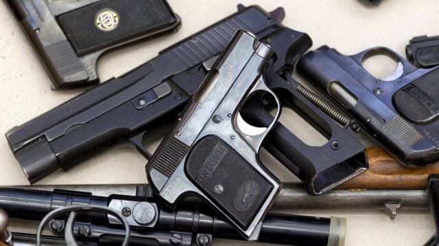 Mehrere Schusswaffen auf einem Tisch. Mehrere Schusswaffen auf einem Tisch.