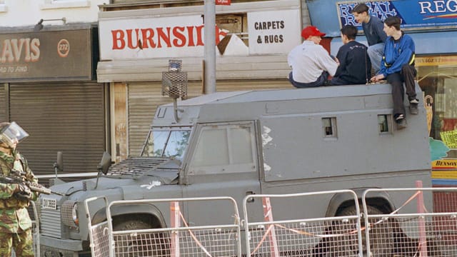 Kinder sitzen auf einem gepanzerten Jeep. Kinder sitzen auf einem gepanzerten Jeep.