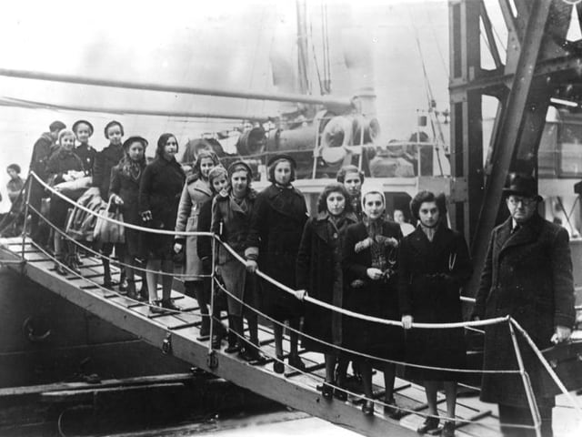 Schwarzweiss-Foto: Etwa 15 Kinder und jugendliche auf dem Steg eines Schiffs.