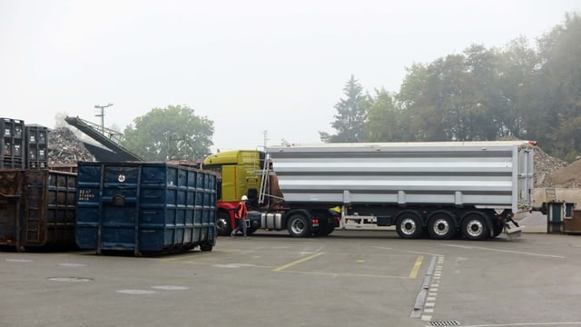 Lastwagen und Container stehen auf einem Recyclinghof Lastwagen und Container stehen auf einem Recyclinghof
