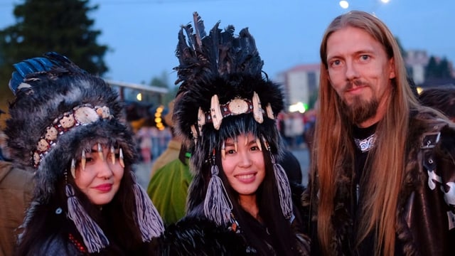 Zwei Tuwinerinnen und ein Tuwiner posieren in ihrer traditionellen Kleidung am Chomej-Festival. Zwei Tuwinerinnen und ein Tuwiner posieren in ihrer traditionellen Kleidung am Chomej-Festival.