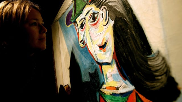 Ein Betrachter schaut auf ein Bild von Picasso. Ein Betrachter schaut auf ein Bild von Picasso.