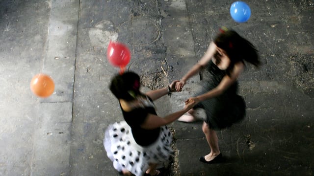 Zwei Frauen, die miteinander tanzen. Luftballons schweben in der Luft. Zwei Frauen, die miteinander tanzen. Luftballons schweben in der Luft.