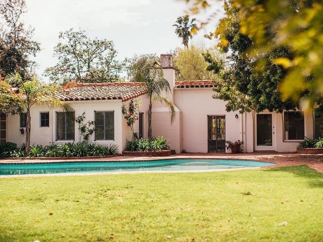 Eine einstöchige Villa im spanischen Stil mit Pool umgeben von einem Garten. Eine einstöchige Villa im spanischen Stil mit Pool umgeben von einem Garten.
