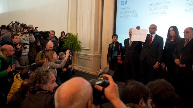 Kommissionschef Ram Manikkalingam zeigt vor Journalisten das Dokument, mit dem die ETA die erste Entwaffnung verkündet. Kommissionschef Ram Manikkalingam zeigt vor Journalisten das Dokument, mit dem die ETA die erste Entwaffnung verkündet.
