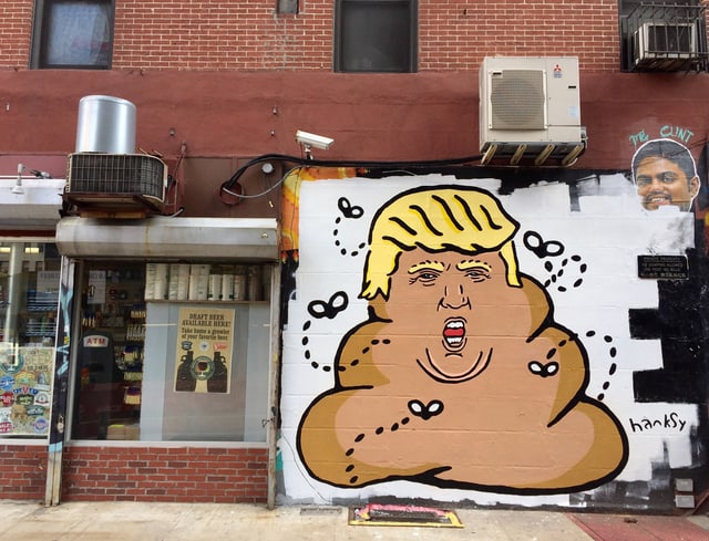 Trump-Darstellung als Kothaufen an einer Hauswand.