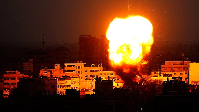 Ein gelber Feuerball steigt in der Nacht über Gaza City auf. Ein gelber Feuerball steigt in der Nacht über Gaza City auf.