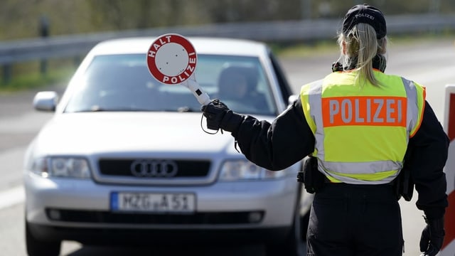 Polizistin hält Auto auf. Polizistin hält Auto auf.