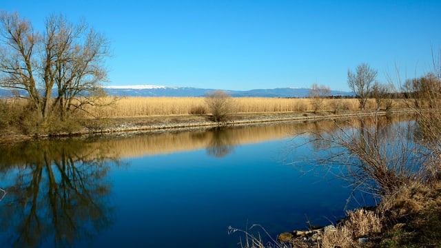 Blick über den blauen Broyekanal, am Horizont der Jura mit dem Chasseral. Blick über den blauen Broyekanal, am Horizont der Jura mit dem Chasseral.