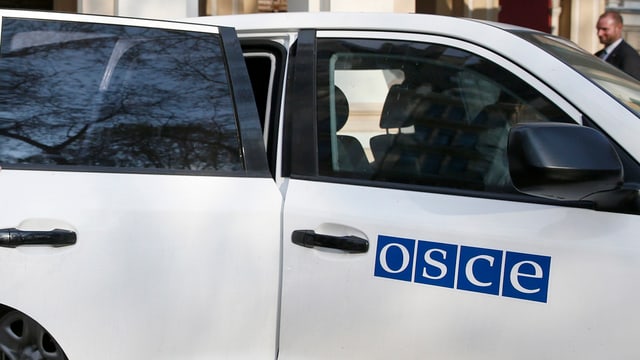Weisses Auto der OSZE mit Schriftzug der Organisation auf der Vordertüre Weisses Auto der OSZE mit Schriftzug der Organisation auf der Vordertüre