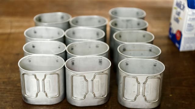 Alu-Trinkbecher neben einer Milchpackung Alu-Trinkbecher neben einer Milchpackung