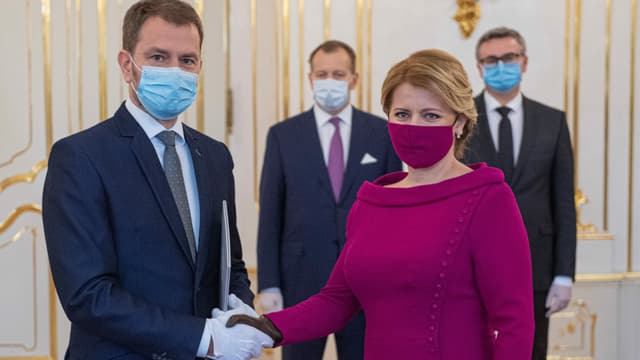 Personen in Schutzmasken geben sich die Hand. Personen in Schutzmasken geben sich die Hand.