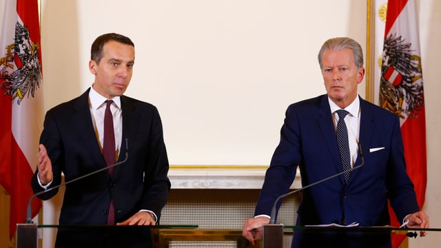 Kern und Mitterlehner stehen an einem Pult vor Mikrofonen, dahinter zwei österreichische Fahnen. Kern und Mitterlehner stehen an einem Pult vor Mikrofonen, dahinter zwei österreichische Fahnen.
