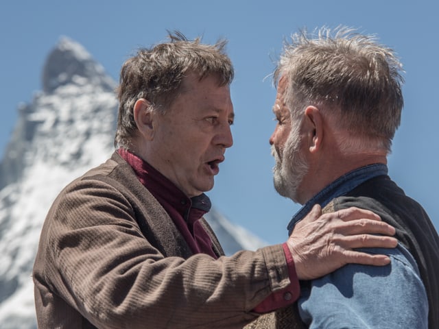 Die beiden Bauern im Theater sprechen miteinander, im Hintergrund das Matterhorn. Die beiden Bauern im Theater sprechen miteinander, im Hintergrund das Matterhorn.