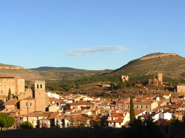 Eine Foto zeigt den spanischen Ort Mora de Rubielos: die Dächer leuchten rot, der Himmel ist blau. Eine Foto zeigt den spanischen Ort Mora de Rubielos: die Dächer leuchten rot, der Himmel ist blau.