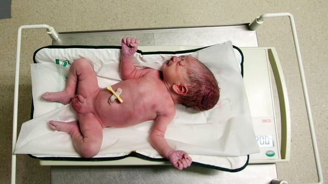 Ein neugeborenes Kind beim Wägen im Spital. 