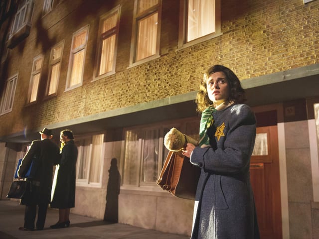 Anne Frank steht vor einem Gebäude. Sie trägt einen Judenstern. Anne Frank steht vor einem Gebäude. Sie trägt einen Judenstern.