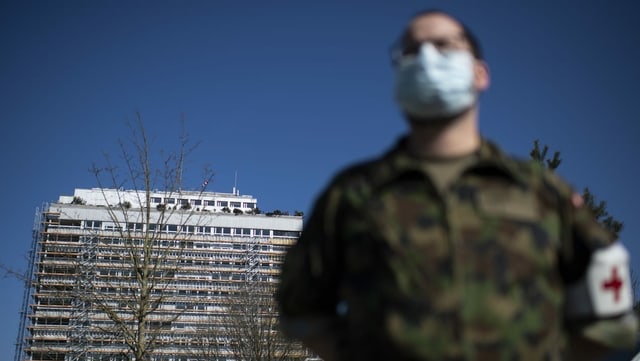 Ein Soldat mit Gesichtsmaske vor dem Bettenhochhaus. Ein Soldat mit Gesichtsmaske vor dem Bettenhochhaus.