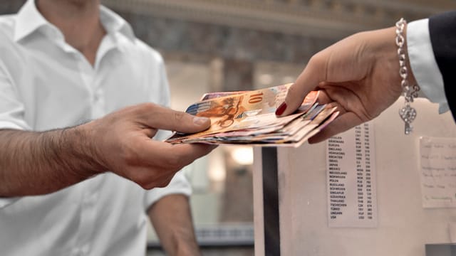 Geld wechselt von einer Hand in eine andere. Geld wechselt von einer Hand in eine andere.