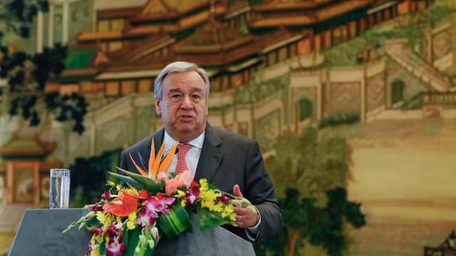 Guterres an einem Rednerpult, auf dem ein grosses Blumenanrrangement liegt. Guterres an einem Rednerpult, auf dem ein grosses Blumenanrrangement liegt.