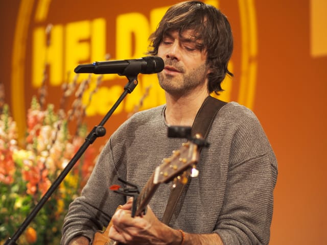Adrian Stern auf der Bühne mit Gitarre.