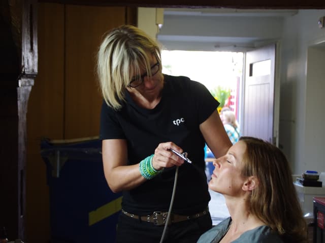 Die Maskenbildnerin besprüht Nicola Spirig mit einem sogenannten Airbrush.