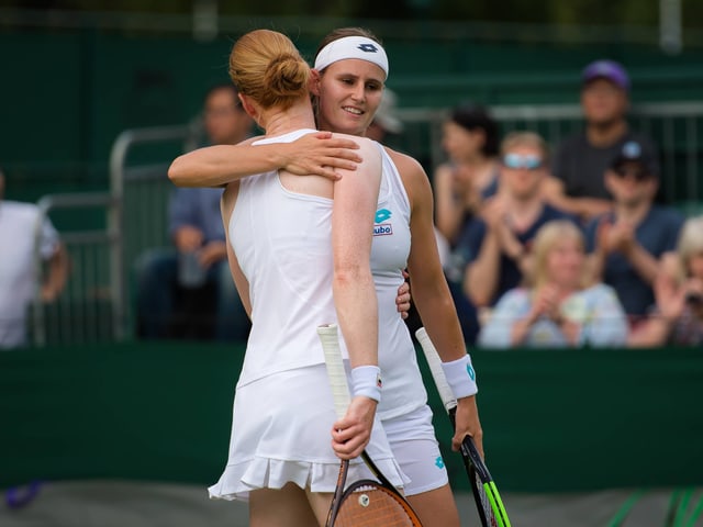 Zwei Tennisspielerinnen umarmen sich. Zwei Tennisspielerinnen umarmen sich.