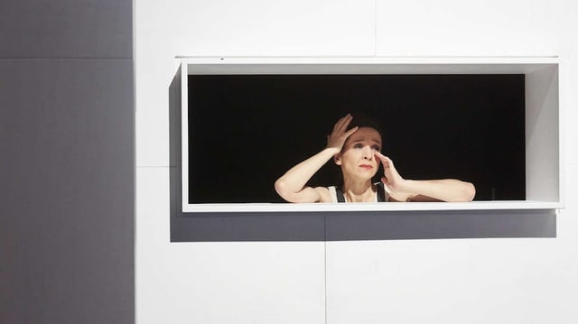 Eine Frau schau aus einem Fenster auf der Theaterbühne. Eine Frau schau aus einem Fenster auf der Theaterbühne.