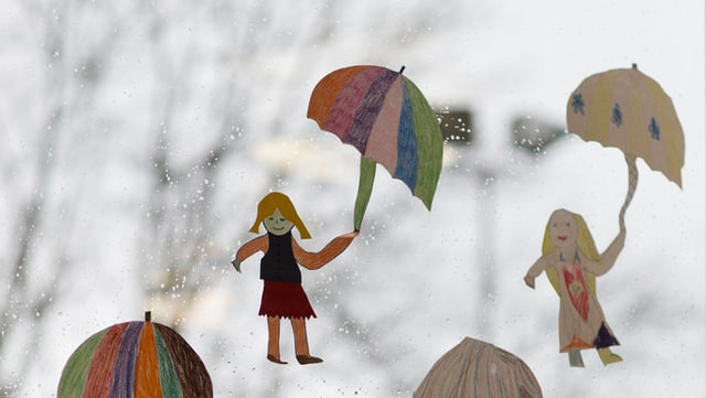 Papierfiguren mit Schirm vor verregneter Fensterscheibe. Papierfiguren mit Schirm vor verregneter Fensterscheibe.